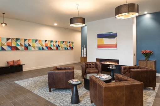 A living room with a fireplace and a painting on the wall. at Ravello Apartments, Redmond, WA
