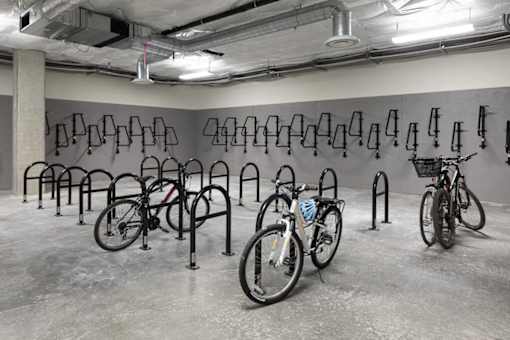 A bike rack with several bicycles parked in it. at Ravello Apartments, Redmond
