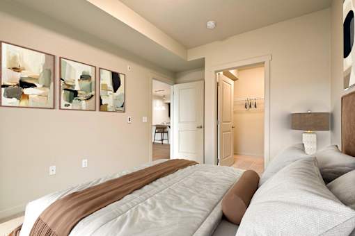 A bedroom with a large bed and a painting on the wall.