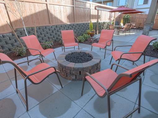 A patio with a fire pit and chairs. at Mill Creek Meadows Apartments, Mill Creek, WA, 98012