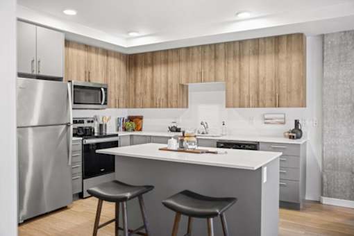 A modern kitchen with a large island and stools. at Riverfront Everett, Washington, 98201