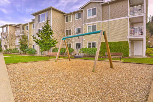 A playground with a slide in front of apartment buildings. at Valley Springs Apartments, Renton, WA, 98058