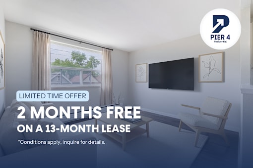 A room with a chair and a television mounted on the wall, advertising a limited time offer for a free 2 months on a 13-month lease.
