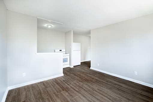 A room with a white wall and a brown floor.