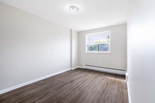 A room with a window and a picture on the wall.