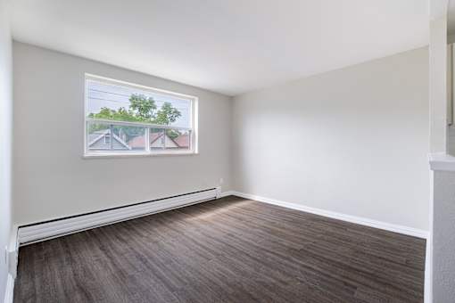 A room with a large window and wooden flooring.