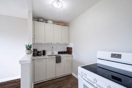 A white kitchen with a white oven and white cabinets.