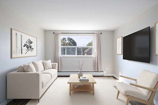A living room with a white couch, a coffee table, and a chair.