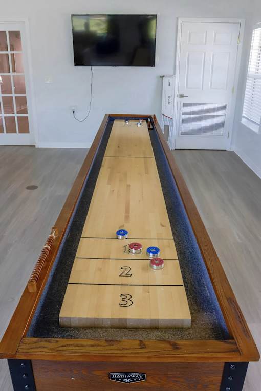 A shuffleboard table with numbered pucks lined up on it.
