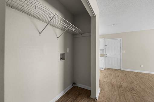 A room with a white door and a white wall with a light switch.