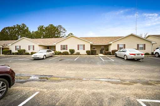 A parking lot with cars parked in front of a building.