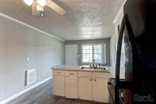 A kitchen with a sink and white cabinets.