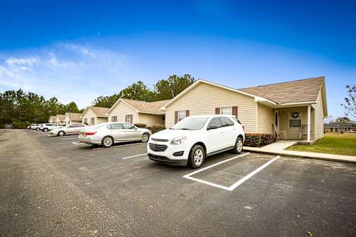 Cars parked in a parking lot in front of a residential building.
