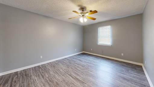 A room with a ceiling fan and a window.