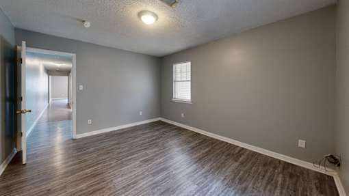 A room with a wooden floor and a ceiling fan.