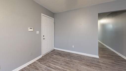 A room with a white door and grey walls.