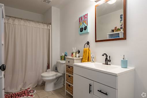 A bathroom with a white sink and a mirror above it.