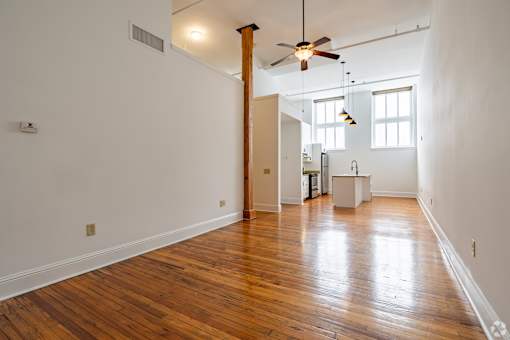 A room with wooden floors and a ceiling fan.