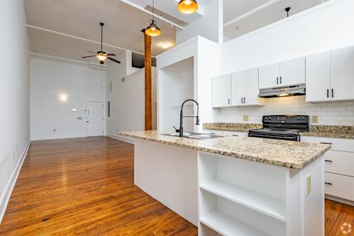 A kitchen with a granite countertop and white cabinets.