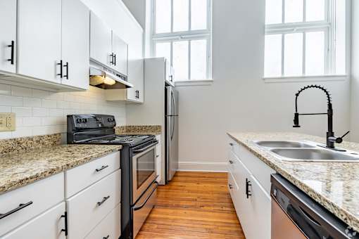 A kitchen with white cabinets and a granite countertop.