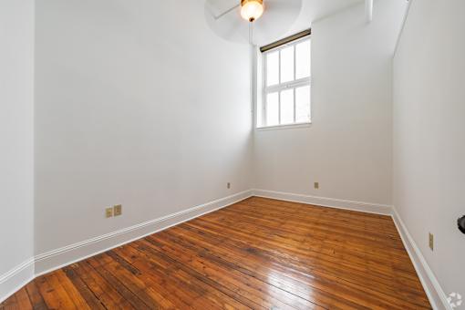 A room with wooden flooring and a window.