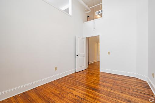 A room with a wooden floor and a white door.