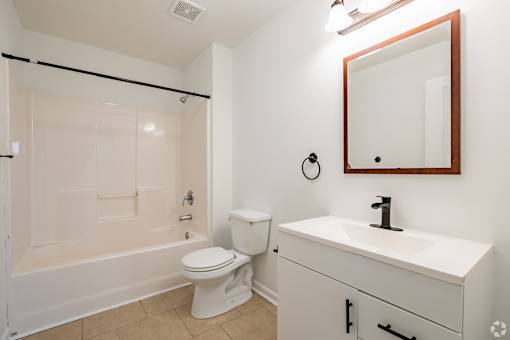A white bathroom with a toilet, sink, and shower.
