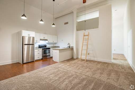 A kitchen with white cabinets and a stainless steel refrigerator.