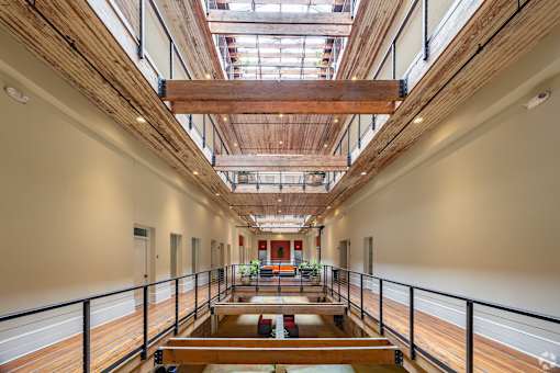 A long hallway with a skylight and a balcony on the right side.
