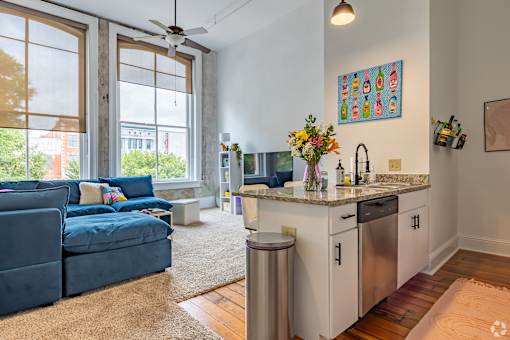 A kitchen with a blue sofa and a fan.