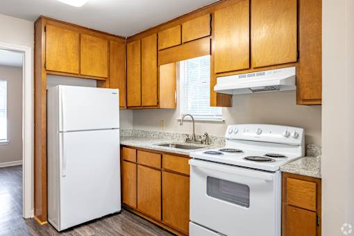A kitchen with wooden cabinets and white appliances.