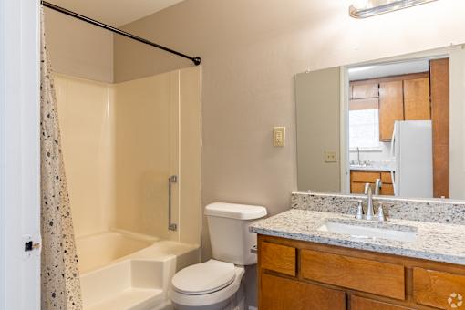 A bathroom with a toilet, sink, and shower.