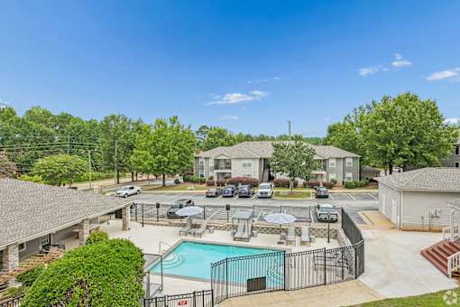 A swimming pool surrounded by a fence and a grassy area.