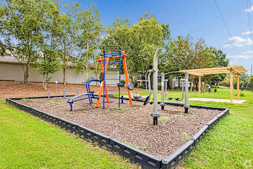 A playground with a swing set and a seesaw.