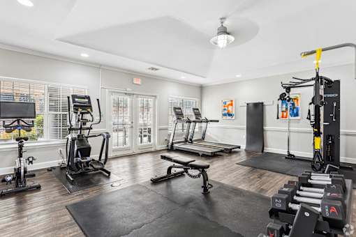 24 Hour gym with a variety of equipment including a treadmill, stationary bike, and weight rack.