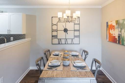 A dining room with a wooden table set for a meal.