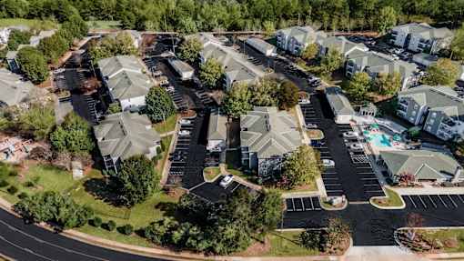 A bird's eye view of a residential area with houses and a parking lot.