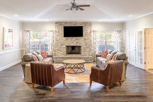 A living room with a fireplace and two chairs.