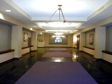 A long hallway with purple carpets and a chandelier hanging from the ceiling.