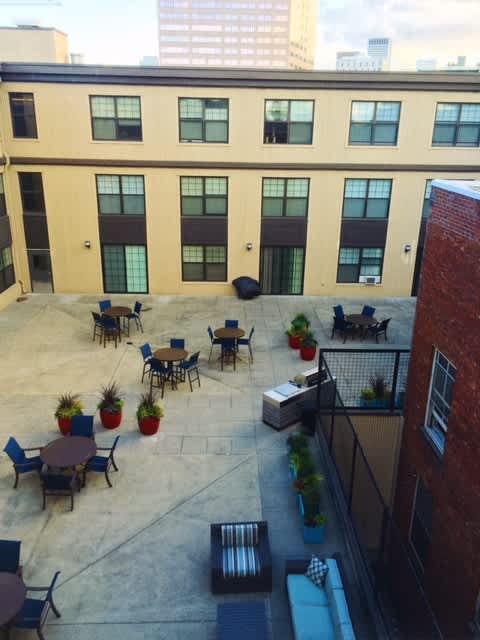 A courtyard with tables and chairs surrounded by buildings.