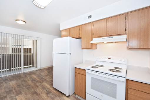 A white refrigerator in a kitchen with wooden cabinets.