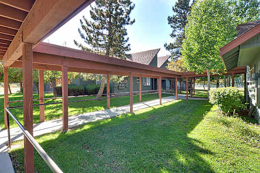 A wooden covered walkway with a metal railing.