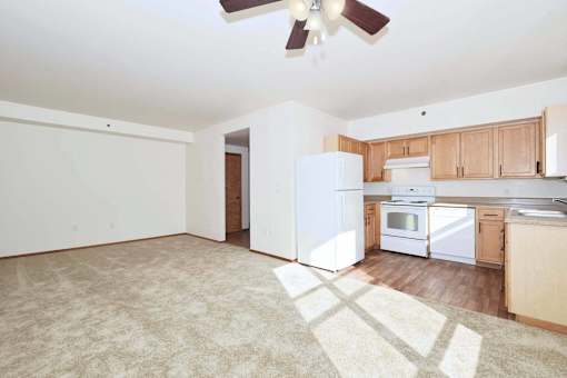 A kitchen with white appliances and wooden cabinets.
