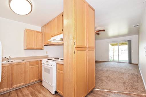 A kitchen with wooden cabinets and a white stove.