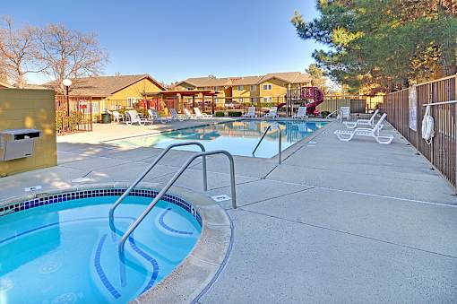 A pool with a slide and a fence.