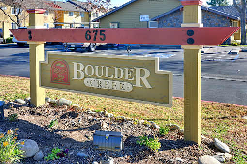 A sign for Boulder Creek with a red and white striped top.