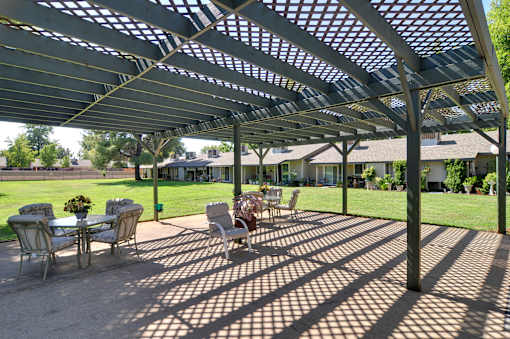 A patio with a table and chairs under a pergola.