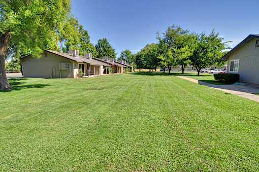 A large grassy field with a building in the background.