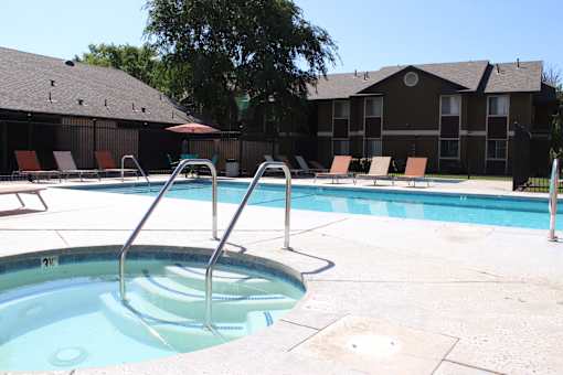 A hot tub sits in the middle of a pool surrounded by chairs.