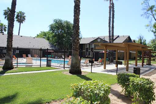 A pool surrounded by a fence and trees.